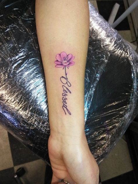 Flower with word stem blessed tattoo on forearm.  @Artsolistattoo Flower Blessed Tattoo, Blessed Flower Tattoo, Beloved Tattoo With Flowers, Blessed Wrist Tattoos For Women, Blessed Wrist Tattoo, Blessed Tattoos For Women, Blessed Rose Tattoo, Word Stem Tattoo, Flower With Word Stem Tattoo