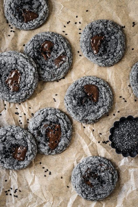 These black sesame cookies have a chewy texture and nutty, sweet taste. The earthy, slightly bitter flavor is more prominent than in white sesame seeds, and pairs nicely with the rich buttery flavor and sugar coated exterior of the cookies. Coarsely chopped chocolate chunks make for an optional extra melty treat. Unusual Cookie Recipes, Black Sesame Chocolate Chip Cookies, Sesame Seed Recipes, Black Sesame Filling, Black Sesame Dessert Vegan, Black Sesame Cookies, Sesame Chocolate, Black Sesame Mochi, Black Cookies