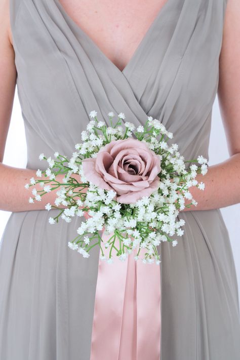 This brides’ bouquet is elegant, romantic, and perfect if you have chosen mauve as one of the accent colors in your wedding. This radiant bouquet is comprised of babies’ breath and a trio of mauve roses. Shining mauve ribbon cascades from this bouquet, adding a chic final touch. This bouquet is a lovely option for those who would like to order their bouquets well before their wedding date, in order to ensure that they are the exact design you had in mind. As usual, our bouquets are expertly craf Small Blush Bouquet, Bridesmaids Bouquets Simple, Wedding Bouquets Bride Simple, Bridesmaid Flowers Simple, Simple Bridal Bouquet, Simple Bridesmaid Bouquets, Maid Of Honor Bouquet, Single Rose Bouquet, Small Bridesmaid Bouquets