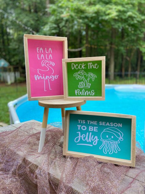 Deck your halls with our coastal Christmas decor! 🐚🎄 You'll get all 3 of our newest signs 🏝️ "Deck the Palms" sign measures 6x6 🦩 Fa la la mingo, measures 6x9  Tis the season so be jelly, measures 6x9 See our other listings for more Coastal Christmas decor! FREE SHIPPING on orders of $35 or more! Deck The Palms Christmas, Christmas In July Decor, Caribbean Christmas Decorations, Deck The Palms, Island Christmas, Tropical Christmas Decor, Christmas In July Party Ideas Decorations, Christmas Beach, Christmas Luau