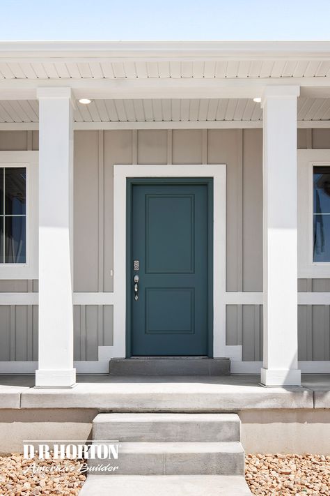 Modern farmhouse with a dark, teal-colored front door paired with grey siding and white trim. Teal Door Gray House, Grey Siding Green Door, Gray House With Colored Front Door, Dark Teal Door Exterior, Gray House With Teal Door, Teal House Exterior White Trim, Tan House With Colored Front Door, Tan Houses With Colored Front Doors, Dark Teal Front Door Sherwin Williams