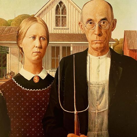 Grant Wood painted this portrait the way a theater director puts on a show. First he discovered the setting. Wood saw the house, now famous for inspiring American Gothic, in a small Iowa town and knew it had to be in a painting. Then he cast his sister and dentist to play the two roles. Many presume them farmer and daughter. But that’s never been nailed down. In fact, the painter left it ambiguous on purpose. Learn more with a click to LadyKflo’s Art Blog. #americangothic #grantwood #region American Gothic Painting, American Gothic House, American Gothic Parody, Grant Wood American Gothic, Front Of A House, David Choe, Artemisia Gentileschi, Istoria Artei, Grant Wood