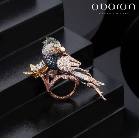 #uncage your deepest fantasy. Beautiful bird ring ,adorned with tsavorite on the head,a blue sapphire neck,with wings of 18k rose gold set with diamond.The bird sits on a flower of yellow gold and diamonds perched on a base of rubies Birds Jewelry, Amrapali Jewellery, 3d Ring, Bird Ring, Hand Gestures, Black Beads Mangalsutra Design, New Gold Jewellery Designs, Princess Jewelry, Diamond Pendant Sets