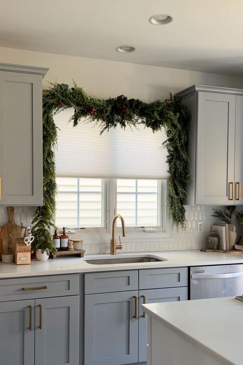 Here's Proof the Viral Christmas Garland Hack Taking Over TikTok Actually Works Christmas Garland Above Kitchen Sink, Garland Over Kitchen Sink Window, Kitchen Island Garland, Christmas Wreath For Kitchen Cabinets, Above Cabinet Garland, Garland Over Kitchen Sink, Christmas Garland On Windows Inside, Christmas Garland On Cabinets, How To Hang Garland Over Window