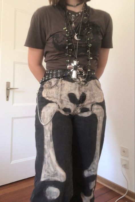 A mid-sized person/girl wearing a brown cropped shirt with a black ape on it and black jeans with bleached skeleton bones on them and a black leather belt, dark brown oxford shoes and multiple crystal rings and bracelets. 		The person is also wearing multiple silver necklaces. Skeleton Aesthetic Outfit, Skeleton Pants Outfit, Diy Goblincore Clothes, Painted Jeans Aesthetic, Skeleton Costume Aesthetic, Forest Gremlin, Crowcore Fashion, Gremlincore Outfits, Crowcore Outfit