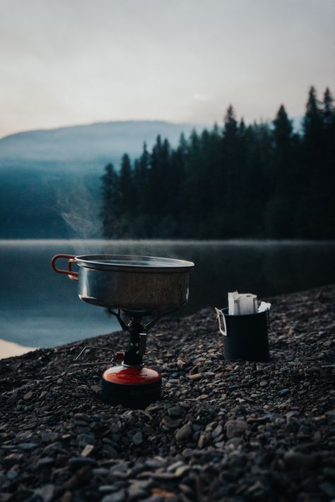 Boiling water on a MSR backpacking stove with a pour over coffee in a cup on a rocky beach in the mountains. Coffee Setup, Outdoorsy Aesthetic, Mountain Lifestyle, Coffee Shot, Earth Photos, Nature Music, Adventure Gifts, Coffee Photography, Adventure Photography