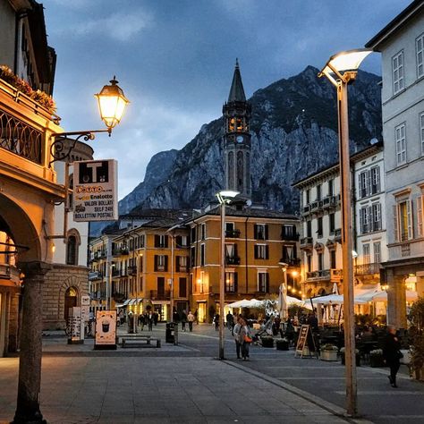 Downtown city street scene at the evening. Lecco, Italy. Picturesque town overlooking lake Como. Square XX Settembre near the old Viscontea tower. Historic center of Lecco city. #downtown #italy #tower #picturesque #lecco #lake #lakecomo #settembre Lecco Italy, City Downtown, City Street, Lake Como, Street Scenes, City Streets, The Old, Tower, Old Things