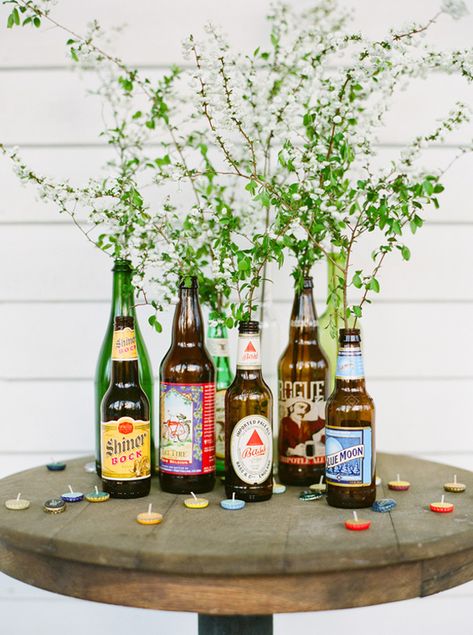 Beer bottle arrangement Beer Centerpieces, Beer Bottle Centerpieces, Beer Bottle Vase, Bottle Cap Candles, White Trash Bash, White Trash Party, Trash Party, Backyard Wedding Decorations, Denim Wedding