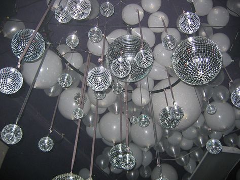 Shiny disco balls and glitter balloons- huge impact for little to no cost.  We could rent the disco balls. Balloons Ceiling, Soul Train Party, Don Perignon, 70s Party Theme, Disco Theme Party, Studio 54 Party, 70s Theme Party, Balloon Ceiling, Disco Birthday Party