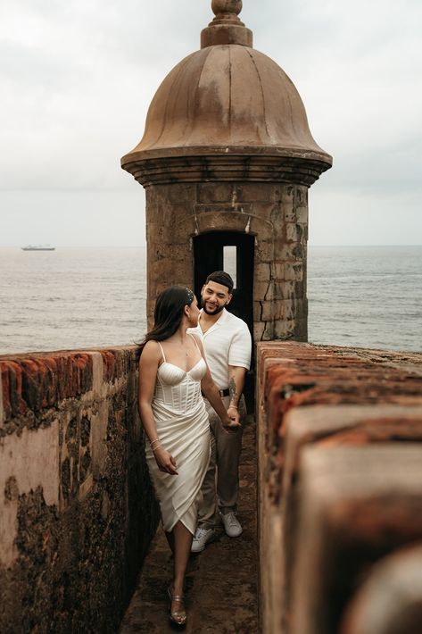 woman in white dress holding hand and leading him forward out of a Spanish fort. Engagement Photos Mission San Juan, San Juan Photoshoot, San Juan Engagement Photos, Latino Engagement Photos, St Augustine Florida Engagement Photos, Engagement Photos Puerto Rico, Spanish Style Engagement Photos, Old San Juan Photoshoot, Old San Juan Engagement Photos