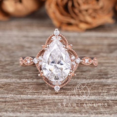 2ct Pear Shaped Moissanite Engagement Ring Art Deco Rose Gold Ring Antique Flower Pear Halo Ring Vintage Style Colorless Vintage Ring Gift * Ring Material: solid 14k rose gold * Center Stone: 2ct pear cut colorless moissanite, D-E-F color, VS clarity * Side Stone: Natural Diamond or Colorless Moissanite, about 0.13ct * Bandwidth: 1.6mm 2-3 WEEKS PROCESSING TIME MADE IN US * Shipping * FREE SHIPPING WITHIN USA! * Certificate * All the items will come with the certificate by me. * Shop Service * √ Vintage Pear Engagement Ring, Pear Halo Ring, Art Deco Rose, Pear Halo, Deco Rose, Moissanite Engagement Ring Halo, Engagement Ring Art Deco, Future Engagement Rings, Oval Cut Engagement Ring