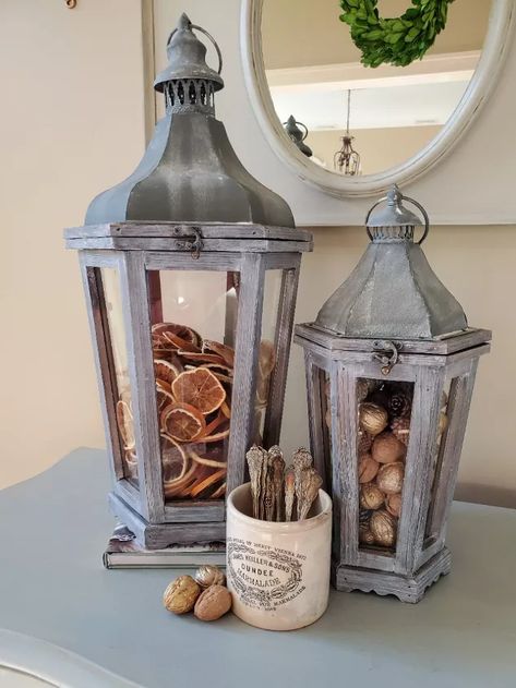 Welcome to Cloches & Lavender where I share crafts, DIY's and Home décor ideas.This is a particularly great time to speak about how to add filler décor to lanterns seasonally. Because the seasons are going to be changing, this is the time we begin thinking about adding warmer touches to our homes.The cooler temperatures that will be here soon makes a fun time to add some of my all time favorite pieces as filler décor for lanterns.How I Updated My Lanterns To Lighten ThemSo, now, le… How To Decorate A Lantern, Lantern Filler Ideas, Ceramic Crock, Plant Stands Outdoor, Large Lanterns, Berry Baskets, Diy Plant Stand, Dried Oranges, Dried Orange Slices