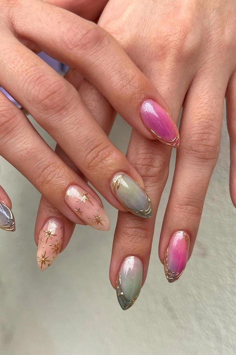 These almond-shaped nails boast a dreamy aesthetic. Featuring an iridescent finish that shimmers with a pearly luster, some nails are kissed with a delicate gradient of pink to lilac. Other nails are embellished with tiny golden stars scattered across a soft pink base, adding a touch of whimsical elegance. The look is perfectly sealed with a chic, gold-tipped outline, exuding an ethereal charm. Simply enchanting! ✨  // Photo Credit: Instagram @gloss.cee.nails Tiny Nails Ideas, Nails Whimsical, Whimsical Nail Designs, Fairytale Nail Art, Pink And Golden Nails, Ethereal Nail Art, Nails Pink And Gold, Ethereal Nail Design, Iridescent Butterfly Nails