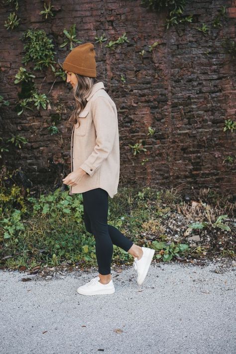 ashley wearing a tan shacket, black leggings, white sneakers, and brown beanie standing in front of a rock wall with green plants Casual Outfits Leggings Fall, Fall Outfits Tennessee, Fall Airforce 1 Outfit, Cream Fleece Shacket Outfit, Brown Leggings Outfit Work, Shacket Outfit With Leggings, Blush Pink Shirt Outfit, Comfy Shacket Outfits, Comfy Shopping Outfit Fall