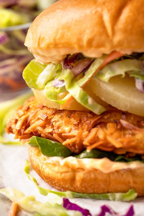 This coconut crunch chicken sandwich is piled onto a soft brioche bun with slices of pineapple plus cool, creamy coleslaw and sriracha mayo! | thecozyapron.com #chickensandwich #coconutcrunchchickensandwich #coconutchickensandwich #crispychickensandwich Crispy Chicken Sandwiches, Chicken Breast Cutlet, Creamy Coleslaw, Coconut Chicken, Sandwich Ingredients, Chicken Sandwich Recipes, Honey Chicken, Brioche Buns, Chicken Sandwich