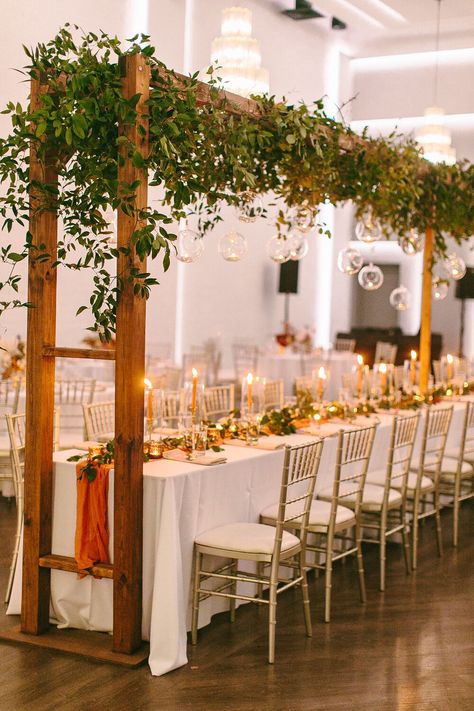 Head table installation at the Clay Theatre Wedding Venue in Green Cove Springs. The bride had a custom 24' arbor made for her head table, greenery and hanging tea lights by Wild Thistle Co in Jacksonville Florida, Planning by Cherish Events. Trellis Over Table, Wedding Head Table Trellis, Head Table For Wedding, Head Table Greenery, Table For Wedding Reception, Wild Thistle, Table Installation, Table Greenery, Table For Wedding