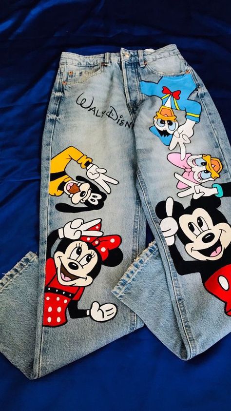 🌟 Features: 🐭 Mickey Mouse 🦆 Donald Duck 🐶 Pluto 🎨 Each detail on these jeans is meticulously hand-painted, ensuring that no two pairs are exactly alike. Whether you're a Disney enthusiast or simply appreciate unique fashion, these jeans are a must-have addition to your wardrobe. 👖 Jeans Details: Premium denim fabric for durability and comfort. Classic five-pocket design for practicality. Painted Jeans Designs, Hand Painted Clothing Diy, Jeans Painting Ideas, New Jeans Jeans, Jeans Skirt Outfit, Jeans Painting, Disney Jeans, Jean Top Outfits, Custom Jeans Diy