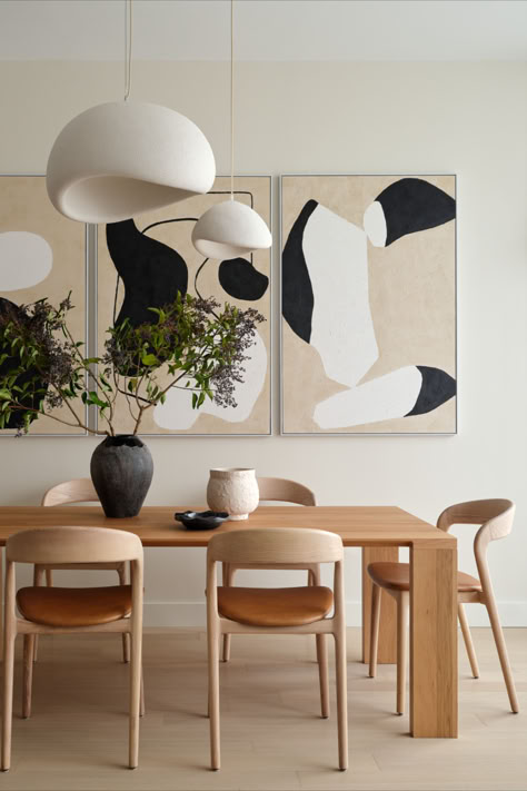 A contemporary Japandi inspired dining room. The luxury condo has expansive views of the Boston skyline. The furniture details feature a white oak dining table, white oak and leather dining chairs, custom organic black and white wall art, and white oversized japandi pendants. Japanese Interior Design Dining Room, Japandi Dining Table Round, Japandi Condo Interior, Japandi Interior Design Dining Room, Japandi Table Decor, Japandi Dinner Table, Japandi Dining Chairs, Dining Room Black Table, Japandi Dining Area