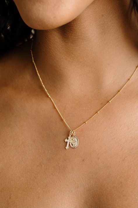 D E T A I L S  A dainty miraculous medal pendant and delicate cross hangs beautifully from our signature delicate & sparkly cable chain or beaded chain.   The pendant features the Virgin Mary on the front, and on the back the letter M with a cross, the Sacred Hearts of Jesus & Mary, a crown of thorns, and a heart pierced by a sword.  The cross is dainty and has a raised ornate design. Cross measures 9.5mm wide x 15.5mm tall. Oval mary pendant measures 8mm wide x 14mm tall. Created from 14kt gold Necklace With Cross, Mary Necklace, Heart Piercing, Virgin Mary Necklace, Catholic Necklace, Catholic Jewelry, San Clemente, Jewelry Lookbook, Miraculous Medal