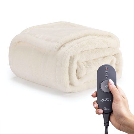 Snuggle up with the Sunbeam Faux Fur Heated Electric Throw to beat those winter chills. Indulge yourself with its ultra silky faux fur material to keep you toasty while you unwind. This stylish throw makes for a beautiful accent to any decor. Easy to use detachable controller with 3 heat settings and a 3-hour auto-shut off feature for peace of mind. Remove the controller and place the blanket into the washer and dryer for easy cleaning. Size: 50 x 60.  Color: White. Christmas Wishlist Items, Cream Throw Blanket, Heating Blanket, Luxury Stuff, Wallpaper Pink Cute, Cheap Blankets, Cream Throw, Bed Accessories, Mobile Home Decorating