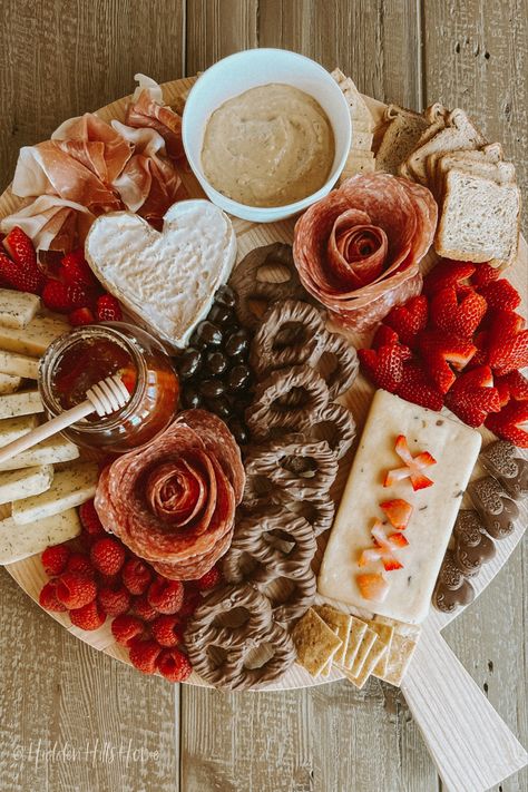 Valentine’s Day inspired charcuterie board with heart shaped fruit, cheese, chocolate, and snacks!