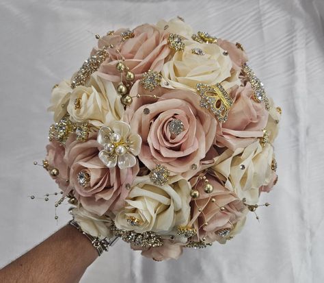 Handmade quinceañera bouquet with Blush Pink and Dark Champagne roses. Finished off with Gold brooches. Décor can be changed upon request. *This is a made to order bouquet* *Please note brooches can change in style based on availability* Ramo Flowers For Quince, Pink And Gold Theme Quinceanera, Rose Gold Quince Bouquet, Quinceanera Flower Bouquet Pink, Quince Decorations Pink And Gold, Rose Gold Quinceanera Centerpiece Ideas, Pink And Rose Gold Quinceanera Dress, Pink And Gold Quince Cake, Pink Quince Bouquet