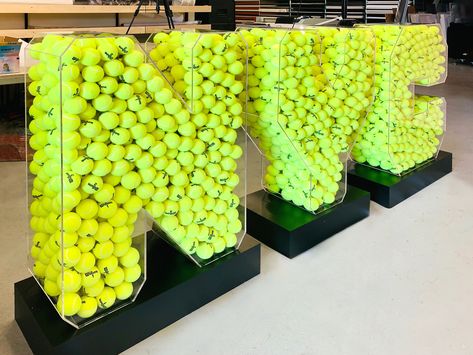 Freestanding NYC 3 dimensional letters full of tennis balls. The letters on this event sign are made of durable acrylic and the base is made of high-quality aluminum. Sports Activation Ideas, Tennis Activation, Logo Signage, Ball Display, Sign Boards, Tennis Party, Tennis Event, 3d Signs, Sports Event