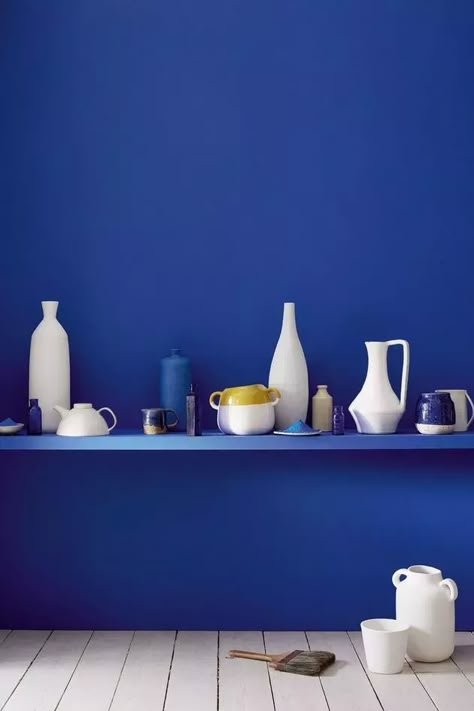 Un joli mur de cuisine de couleur bleu indigo avec une étagère simple où sont posé des ustensiles de cuisine et des objets de décoration, des vases, des coupelles, des bols, le tout dans une salle avec un parquet en bois clair Bright Blue Paint, Yves Klein Blue, Blue Is The Warmest Colour, Mad About The House, Ultra Blue, Yves Klein, Blue Inspiration, Little Greene Paint, Blue Rooms