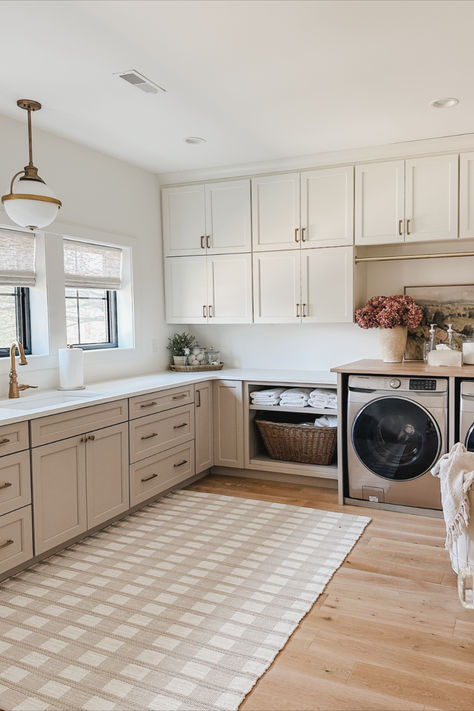 Bright and airy laundry space with faux florals and neutral area rug. With our laundry room being highly utilized it was important to keep this space aesthetic yet functional   Spring home, light and bright, laundry room, neutral area rug, organization details, aesthetic home, lighting details, gold detail, laundry basket, laundry organization, faux florals, found it on Amazon, Target, basket faves, towel finds, spring refresh, aesthetic organization, neutral laundry room Beige Cabinets Laundry Room, Laundry Room Taupe Cabinets, Light Oak Cabinets Laundry Room, Bronze Hardware Laundry Cabinets, Laundry Room Hanging Bar, Laundry Roon Wallpaper, Vintage Laundry Room, Large Laundry Rooms, Laundry Room Renovation