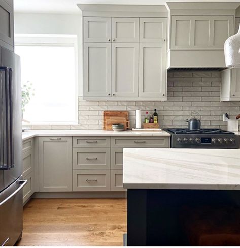 Learn all about the undertones and LRV of Benjamin Moore Revere Pewter. Shown here slightly darkened on painted maple cabinets, white oak flooring, warm gray subway tile backsplash and Cambria Brittanica Warm white quartz countertop. Kylie M Interiors Edesign  #quartzcountertop #reverepewter #benjaminmoore #graycabinets #paintedcabinets #subwaytile #graykitchen #whiteoak #edesign #kylieminteriors #kyliemedesign #colourconsultant #bestpaintcolours