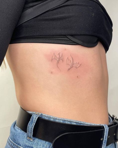 Fine line dragons tattooed on the rib. Back Tattoo Dainty Women, Tiny Delicate Tattoos, Tiny Dragon Tattoo For Women, Lion Dragon Tattoo, Dragon Tattoo Minimal, Minimal Dragon Tattoo, Dainty Rib Tattoos, Dainty Rib Tattoos For Women, Dragon Tattoo Simple