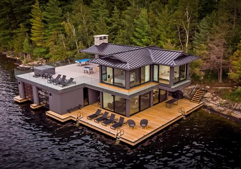 Lake Rosseau Contemporary Boathouse Located on beautiful Lake Rosseau, this extraordinary boathouse-cum-guesthouse was designed to bridge the gap between function and style. Large windows provide modern appeal and uninterrupted lake views, while the use of clear cedar in the boat storage area strikes a note of classic Muskoka charm. A covered lounge Boat House Ideas, Elevated Houses, Diy Dock, Boathouse Design, Lakeside House, House On The Water, Boat Docks, Prefab Home, Lakefront Living