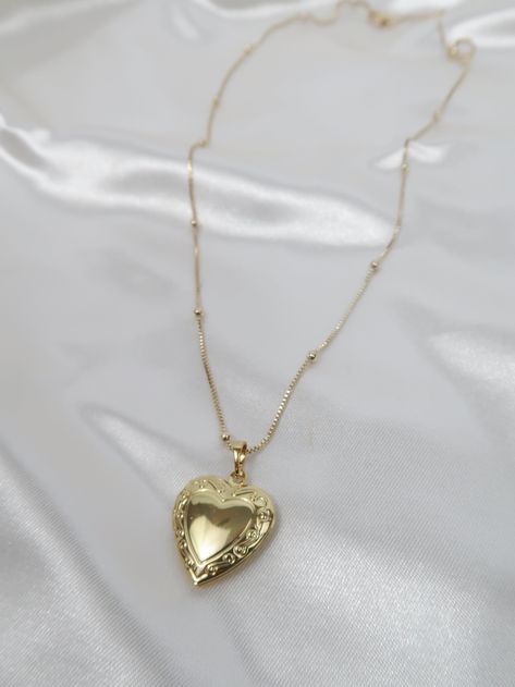 Vintage meets dainty. This heart locket is pure perfection! Add your favorite photo to hold to your heart forever. Length: 18in, 20in Pendant: Size : 27mmx19.2mm Model wearing 20in Vintage Lockets Necklace, Gold Locket Aesthetic, Heart Gold Necklace, Vintage Locket Necklace, Vintage Heart Locket, Heart Pendent, Gold Heart Locket, Gold Locket Necklace, Heart Locket Necklace