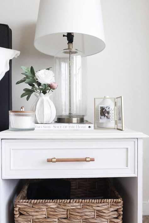 Gold, white and wicker bedside table decor. We DIY'ed the table from a Facebook Marketplace, added on the wood and gold pull, and then completed the set up with antique-inspired table decor. Side Bed Table Decor Ideas, Side Table Set Up, Guest Bedside Table Decor, Nightstand Decor Ideas Minimalist, Small Table Bedroom, Side Table Decor With Lamp, How To Decorate Bed Side Tables, Style A Bedside Table, Bedside Table Styling No Lamp