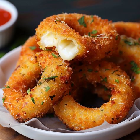 Embark on a culinary adventure with 'Crispy Delight: Mozzarella Stick Onion Rings,' where the beloved appetizer meets innovative cooking. This mouthwatering creation combines the gooey, stretchy joy of mozzarella sticks with the sweet, savory crunch of onion rings, resulting in a fusion snack that's sure to captivate and satisfy. Perfect for parties, game day gatherings, or as a novel treat for family movie nights, these mozzarella stick onion rings offer a fun and flavorful twist on classic ... Mozzarella Stick Onion Rings, Baked Mozzarella Onion Rings, Quick Savory Snacks Simple, Recipes That Use Mozzarella Cheese, Mozzarella Appetizers Appetizer Ideas, Food Cravings Vegetarian, Mozzarella Onion Rings, Mozzarella Donut, Onion Rings Aesthetic