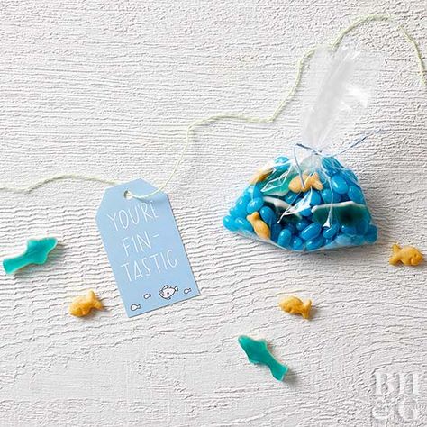 There's nothing scary about this shark-theme party favor! Celebrate an underwater adventure with our printable gift tags and a bag of ocean-inspired treats like fish-shape crackers, gummies, and jelly beans. Underwater Party Favors, Shark Themed Birthday Party Favors, Ocean Theme Favors, Aquarium Birthday Party Favors, Ocean Party Favors, Diy Kids Party Favors, Beach Birthday Decorations, Under The Sea Birthday Giveaway, Shark Party Favors Waterbottles