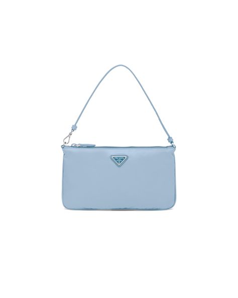 Characterized by a sleek line and emphasized by the iconic enameled metal triangle logo, this mini bag is made of Prada's innovative Re-Nylon fabric produced from recycled plastic materials collected in the ocean. The accessory has a leather strap that lets you also wear it over the shoulder. Tas Coach, Prada Mini Bag, Prada Mini, Bag Prada, Triangle Logo, Bag Trends, In The Ocean, Accessory Pouch, Leather Wristlet