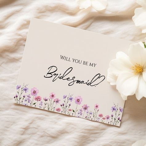 This modern wildflower wedding bridesmaid proposal card design features a warm beige background adorned with vibrant pink and purple watercolor wildflowers, evoking a sense of timeless romance. The marriage of rustic and elegant boho charm makes this design perfect for couples seeking a modern wildflower aesthetic. Whether you envision a whimsical garden celebration or a chic indoor wedding, this design caters to diverse tastes, ensuring your wedding is as vibrant and special as your love story. Garden Celebration, Wildflower Aesthetic, Wedding Bridesmaid Proposal, Bridesmaid Invitations, Bridesmaid Proposal Card, Watercolor Wildflowers, Bridesmaid Invitation, Bridesmaid Proposal Cards, Be My Bridesmaid Cards