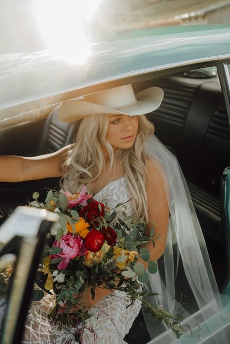 Stunning bride in cowgirl hat sitting in vintage car - Montana wedding inspiration - bride style Wedding Cowgirl Hat For Bride, Cowgirl Hat Wedding Dress, Cowboy Hat With Wedding Dress, Bride With Cowboy Hat, Cowboy Beach Wedding, Cowgirl Wedding Hat, Cowgirl Hat Veil, Black Cowboy Hat Wedding, Wedding Hair With Cowboy Hat