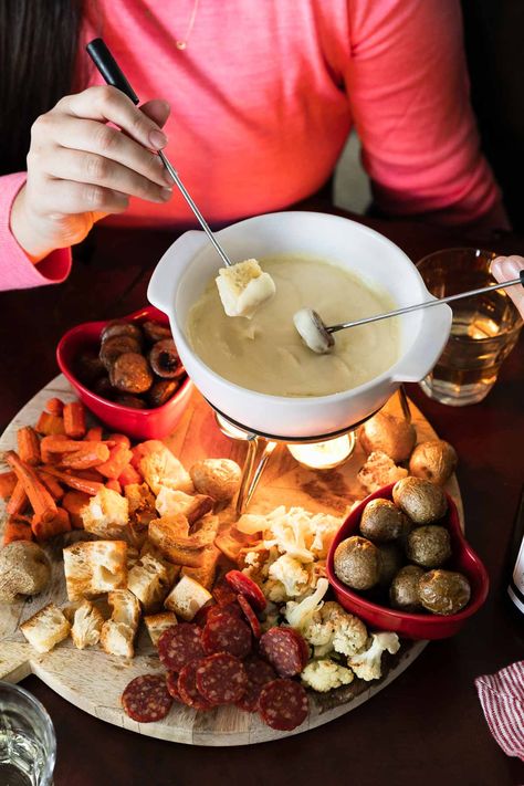 Cheese Fondue for Two: a classic cheese fondue recipe, scaled to the perfect portion to share with your sweetie for a fun & romantic date night at home! 3types of cheese slowly melt into a garlicky white white sauce, creating an irresistibly rich & creamy fondue. Pair with your favorite dippers – roasted vegetables, sausage, bread, salami, & more! – this homemade fondue is an easy-yet-special recipe for Valentine's Day or your next cozy date night in! #fonduerecipes #fondueideas #datenightideas Valentines Fondue Dinner, How To Make Fondue Cheese, Special Meals For Two, Fancy At Home Date Night, Valentines Fondue Board, Fondue Dinner For Two, Valentine’s Day Fondue, What To Serve With Cheese Fondue, Fondue Ideas Cheese