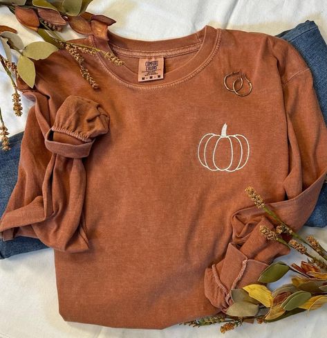 It's that time of year, you know what time...Pumpkin Time!  The days become shorter but they sure seem to slow down.  Our simple pumpkin outline tee is the perfect way to show you love the season in perfect minimalist style.   The softest and most cozy Comfort Colors tee with a cute fall style!  Pair with your favorite jeans, or size up one and grab your comfy leggings!  You are choosing Long Sleeve or Short Sleeve Shown here in the long sleeve option with cream thread.  If you prefer a differen Fall Shirts Simple, Pumpkin Patch T Shirts, Fall And Halloween Shirt Ideas, Fall Embroidery Shirts, Thanksgiving Graphic Tees, Cute Tshirt Designs For Women, Fall Cricut Shirts, Circuit Shirt Ideas, Fall Tshirt Ideas