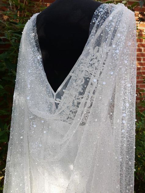 Add a touch of ethereal elegance to your wedding day ensemble with our exquisite Light Ivory Wedding Cape Veil. This beaded cathedral cloak is thoughtfully designed to create a stunning silhouette as you glide down the aisle. Handcrafted with meticulous attention to detail, this cape veil features intricate beadwork that adds a hint of sparkle to your bridal look. The light ivory hue exudes a timeless charm, effortlessly complementing any wedding gown. With its cathedral length design, this cape veil gracefully trails behind you as you make your grand entrance. Elevate your bridal style and leave a lasting impression with this enchanting wedding accessory. Colour: off-white (light ivory). Please, message me if you need custom colour or length. Size: 300CM*150CM -------------------- Interna Ethereal Wedding Veil, Cape Veil Wedding, Bookish Wedding, Bridal Cape Veil, Wedding Cape Veil, Ethereal Bride, Cape Veil, Ivory Bridal Veil, Wedding Cloak