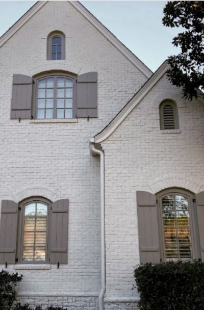 Using white painted brick on our house, and 7 other stunning white brick painted homes and the paint colors they used. White brick never goes out of style! White Brick House, White Painted Brick, Brick House Designs, Painted Brick Exteriors, Chrissy Marie, Painted Brick House, Transitional Exterior, House Paint Color Combination, Brown Roof