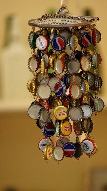 I'm gonna do this!  what a great idea for bottle caps. i was going to use them for tiles on an outdoor table top but this is cute too! Bottle Top Crafts, Bottle Cap Wind Chime, Carillons Diy, Beer Bottle Caps, Diy Wind Chimes, Diy Outdoor Decor, Beer Caps, Bottle Cap Crafts, Pola Gelang