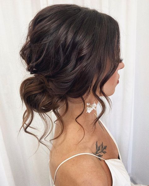 Charming Tousled Bun for Brides Flowy Wedding Hairstyles Loose Updo, Messy Bun For Bridesmaid, Low Bun Wedding Hair Dark Hair, Bridesmaid Low Messy Bun, Wedding Hair For Dark Hair Brides, Loose Side Bun Wedding Hair, Low Bun With Front Pieces Curled, Messy Bridesmaid Bun, Low Messy Bun Bridal Hair