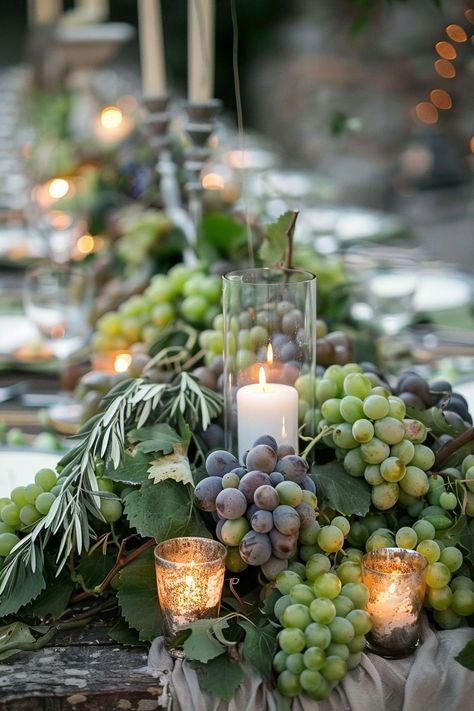 ✨ Elevate your wedding ambiance with a centerpiece that whisks you away to the rolling hills of Tuscany. Experience the charm of Italy as grape vines & olive branches intertwine with the warm glow of candles on your special day. #WeddingInspiration #TuscanWedding #RomanticDecor #WeddingIdeas #CountryChic #RusticElegance #GrapeAndOlive #CandlelightMagic Let the light guide your love story. Tes, Natal, Wedding Table Olive Branch, Olive Leaf Centerpiece Wedding, Grapevine Wedding Decor, Vineyard Table Decor, Tuscan Wedding Centerpieces, Grape Centerpiece Ideas, Olive Branches Decor