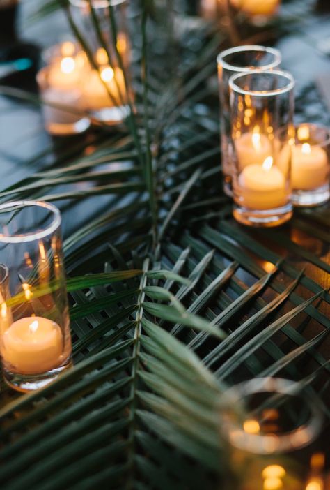 I want EXACTLY this with the regular white tables!! Andee 1/7/18 Tropical Candle Centerpieces Wedding, Palm Table Runner, Tropical Wedding Centerpieces Long Table, Simple Tropical Wedding Table Decor, Palm Tree Table Centerpieces, Tropical Wedding Reception Decor, 100k Celebration, Tropical Table Setting, Hawaii Wedding Reception