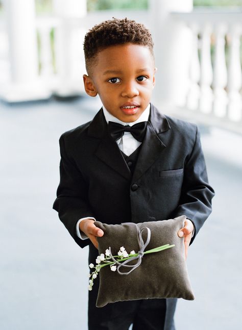 The ring bearer carried a velvet ring pillow with lily of the valley down the aisle. Featured on Martha Stewart Weddings. Ring Bearer Outfit Black, Black Ring Bearer, Grooms Men, Fiji Wedding, Gold Wrap Ring, Bridal Art, Marquise Cut Engagement Ring, College Roommate, Bearer Outfit