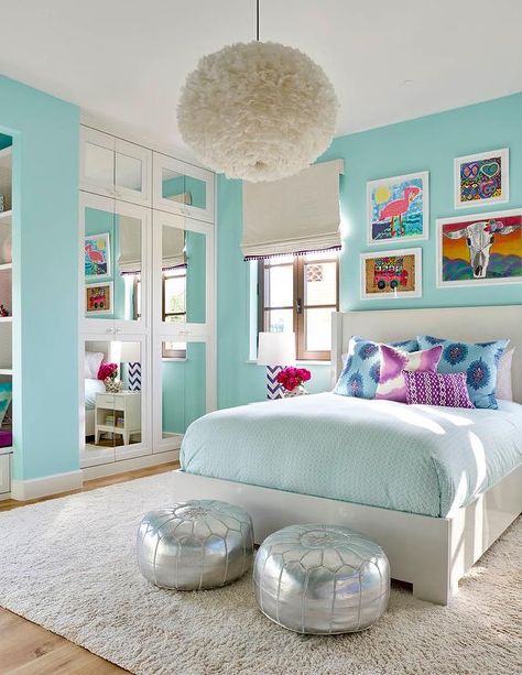 Turquoise blue girl's bedroom features a white feather chandelier, Eos White Pendant, illuminating a white wingback bed dressed in pale blue bedding as well as blue and purple paisley pillows tucked under an eclectic art gallery placed next to casement windows covered in a white roman shade accented with purple tassel trim. Girls Blue Bedroom, Turquoise Room, Bedroom Turquoise, Decor Ikea, Girl Bedroom Designs, Trendy Bedroom, House Beautiful