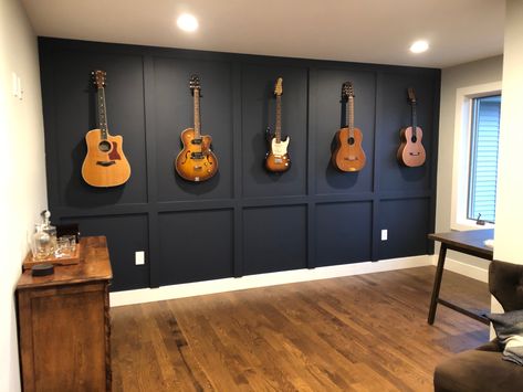 A beatiful way to display guitars. Add a board and batten featured wall! Black Wall Music Room, Cool Home Music Studio, Moody Guitar Room, Living Room Guitar Display, Guitars On The Wall Decor, Guitar Accent Wall, Wall Mounted Guitars, Office With Guitar On Wall, Music Room In Basement